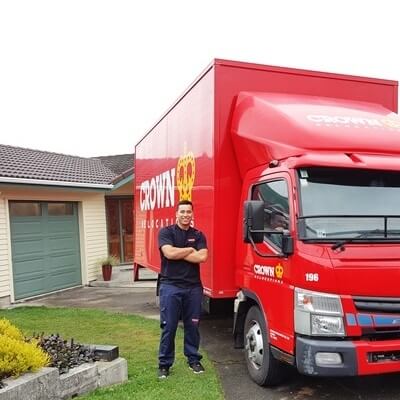 Domestic packer and mover in front of Crown Relocations movers truck