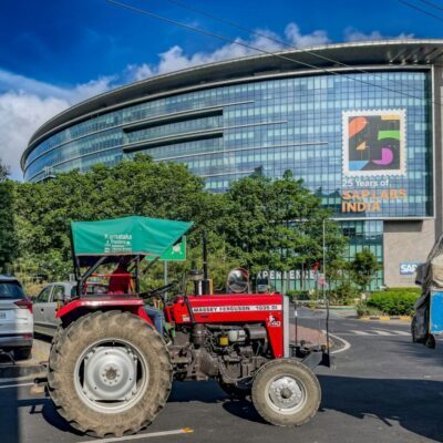 A red Massey Ferguson 1035 DI tractor parked in front of the modern SAP Labs India building in Bengaluru, Karnataka India, photo by Bernd Dittrich